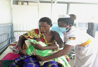 A midwife helping Ayorwoth to breastfeed her baby at Nebbi Hospital. Photo: UNFPA Uganda/Samuel Okiror